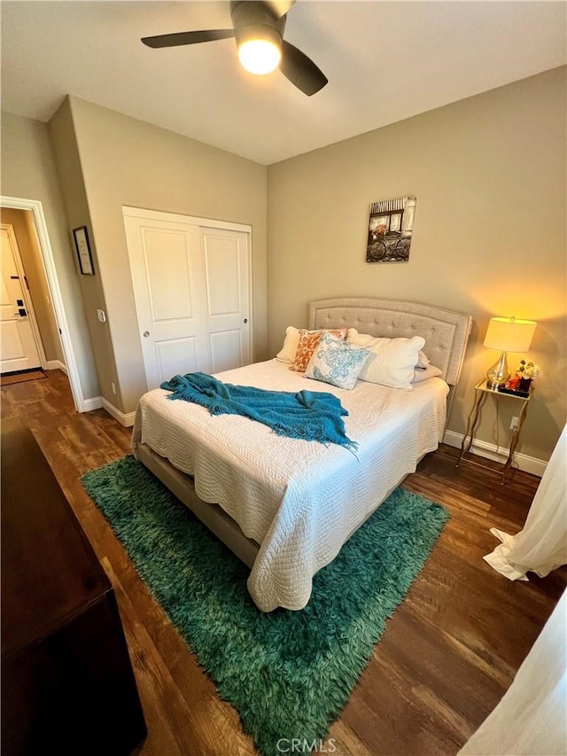 bedroom with ceiling fan, dark hardwood / wood-style flooring, and a closet