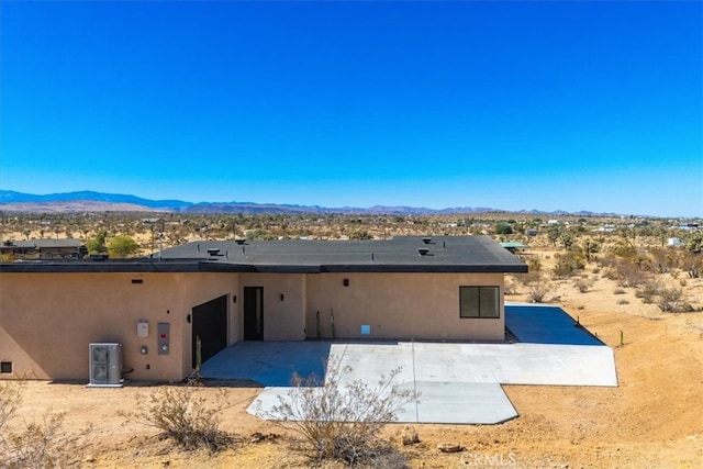 rear view of property featuring a patio and a mountain view