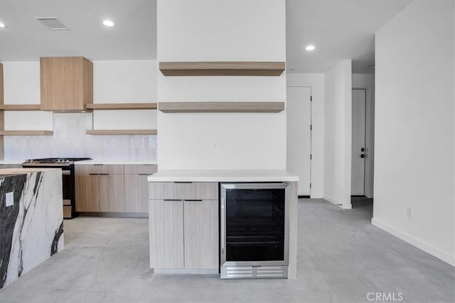 kitchen with decorative backsplash, gas range, wine cooler, light brown cabinetry, and custom exhaust hood