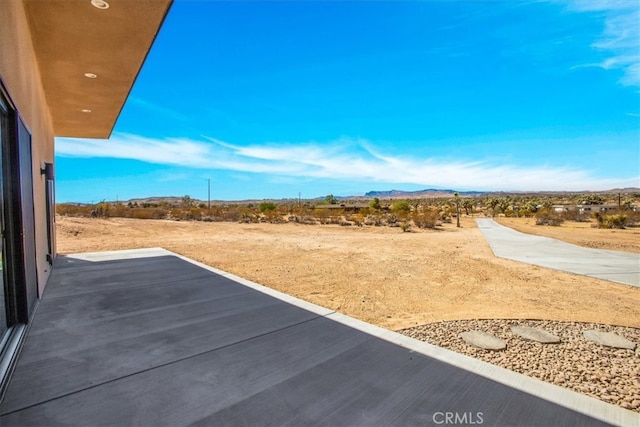 view of yard featuring a mountain view and a patio area