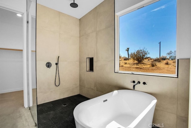 bathroom with tile walls and separate shower and tub