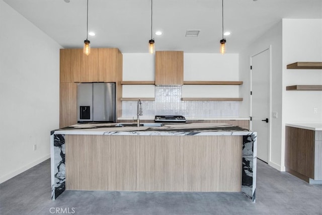 kitchen with concrete floors, stainless steel refrigerator with ice dispenser, pendant lighting, and an island with sink