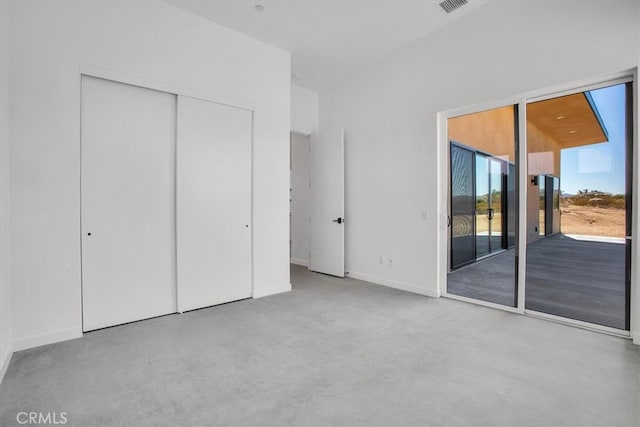 unfurnished bedroom featuring light carpet, a closet, and access to exterior