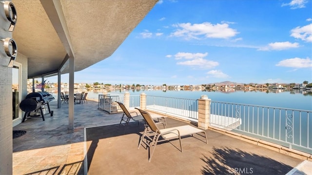 view of patio with a water view and grilling area