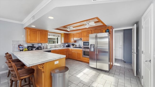 kitchen featuring ceiling fan, stainless steel appliances, kitchen peninsula, and tasteful backsplash