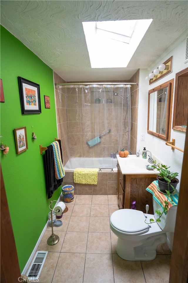 full bathroom with a skylight, vanity, shower / bathtub combination with curtain, tile patterned floors, and toilet