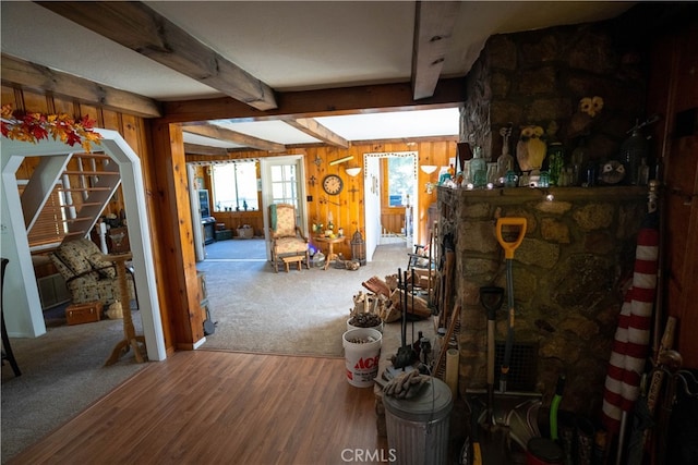 living room featuring hardwood / wood-style flooring, wooden walls, and beam ceiling