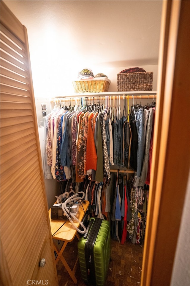 walk in closet with parquet flooring