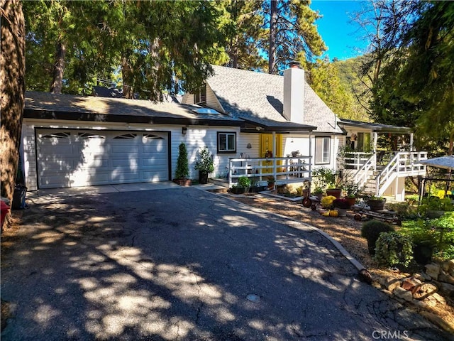507 Valley Dr, Crestline, CA 92325 - view of front of property with an attached garage, driveway, and a chimney