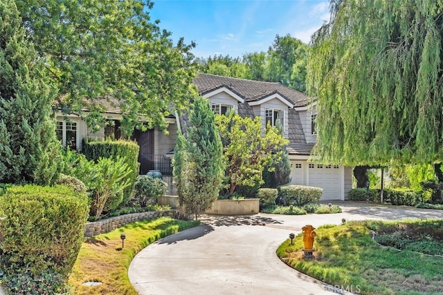 view of property hidden behind natural elements featuring a garage