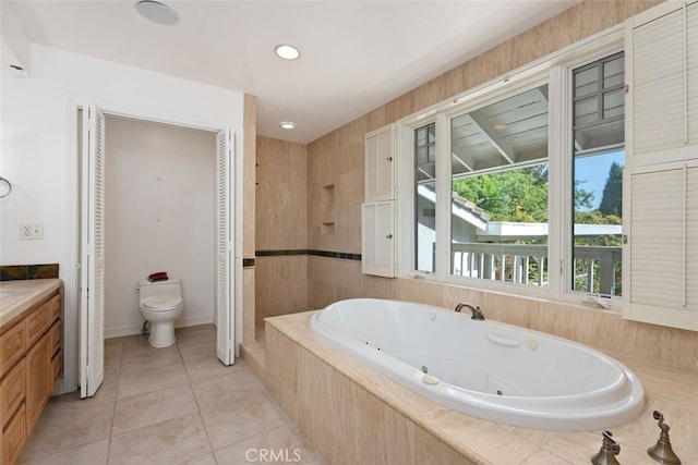 bathroom featuring tile patterned floors, vanity, tiled bath, and toilet