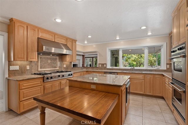 kitchen featuring ornamental molding, a kitchen island, light tile patterned flooring, and appliances with stainless steel finishes