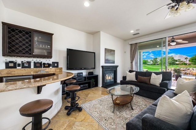 living room featuring ceiling fan and bar