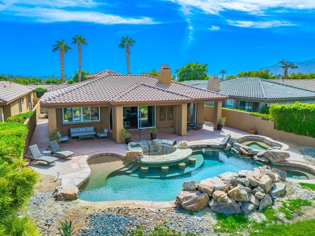 rear view of property with a pool with hot tub and a patio