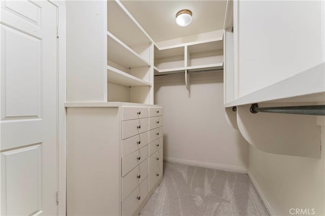 walk in closet featuring light carpet