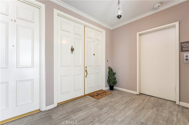 foyer entrance with light wood-type flooring and crown molding