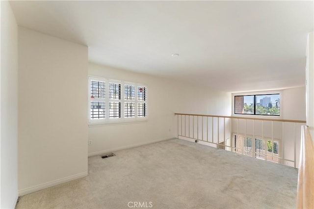 empty room featuring baseboards, carpet flooring, and visible vents