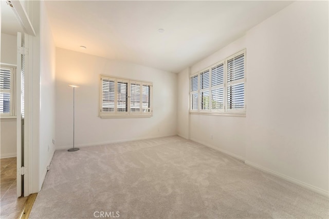 empty room with plenty of natural light and light colored carpet