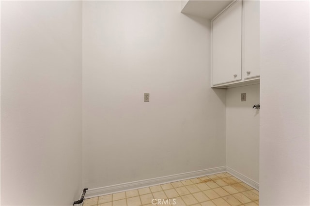 clothes washing area with cabinets