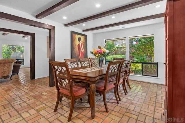 dining area with a healthy amount of sunlight and beamed ceiling