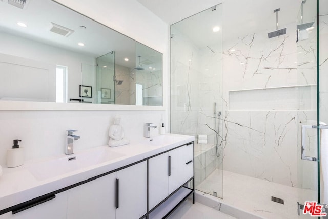 bathroom with a shower with shower door and vanity