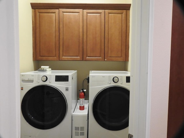 washroom featuring washer and clothes dryer and cabinets