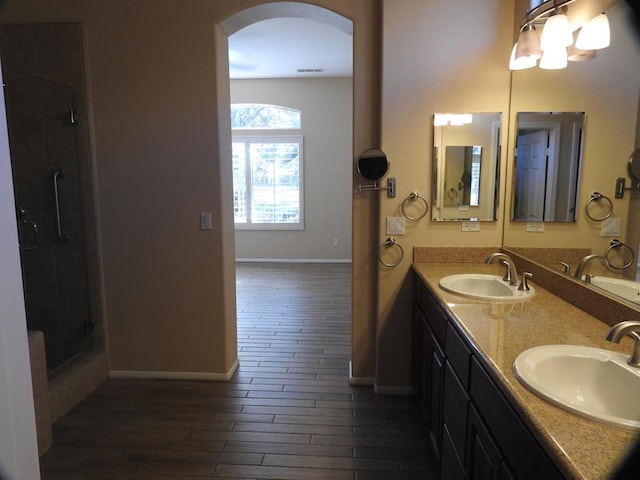 bathroom featuring wood-type flooring, vanity, and an enclosed shower