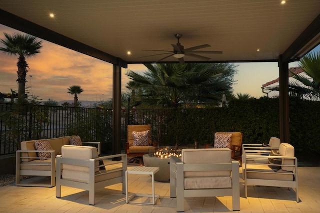 patio terrace at dusk with outdoor lounge area and ceiling fan