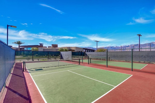 view of sport court with a mountain view and basketball hoop