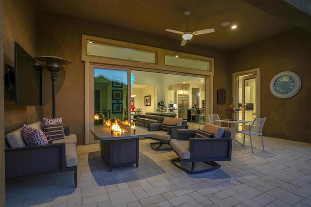 view of patio / terrace featuring ceiling fan and an outdoor living space with a fire pit