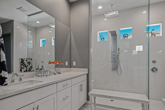 bathroom with vanity and tiled shower