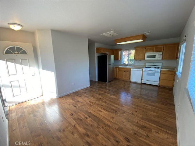 kitchen featuring dark hardwood / wood-style floors, sink, and white appliances