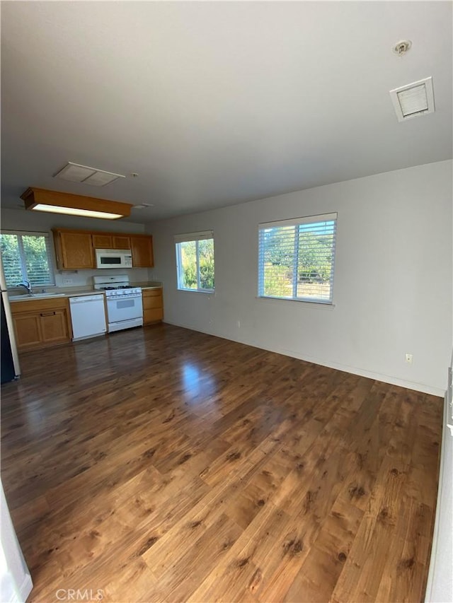 unfurnished living room featuring sink and dark wood-type flooring