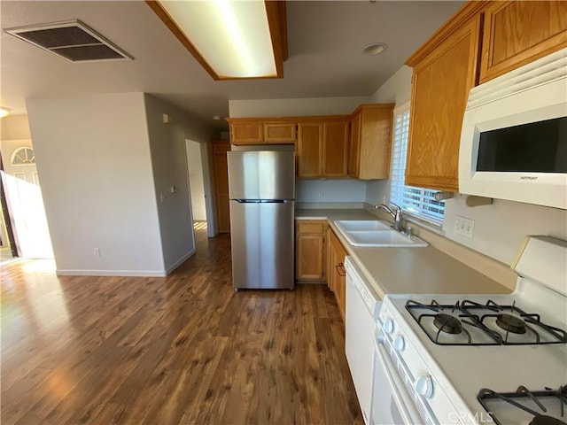 kitchen featuring dark hardwood / wood-style flooring, sink, and white appliances