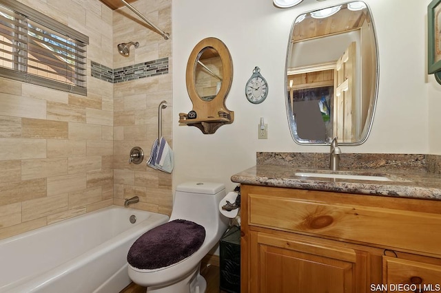 full bathroom featuring tiled shower / bath combo, vanity, and toilet