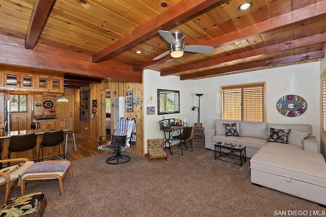 carpeted living room with wood ceiling, plenty of natural light, and wooden walls