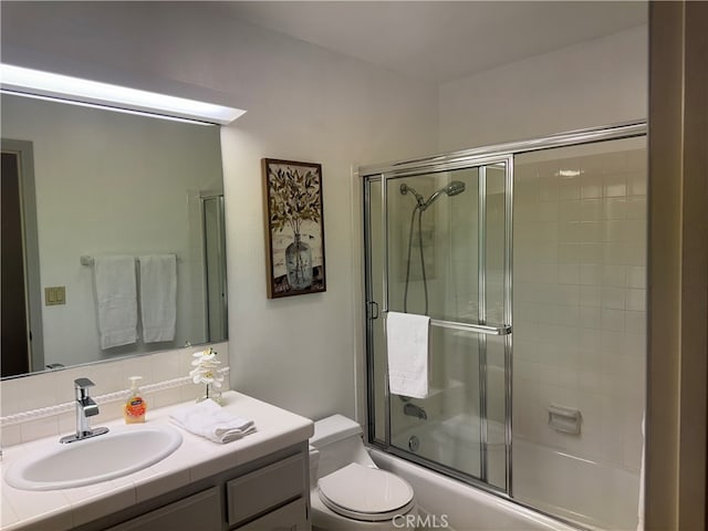 full bathroom with shower / bath combination with glass door, vanity, and toilet