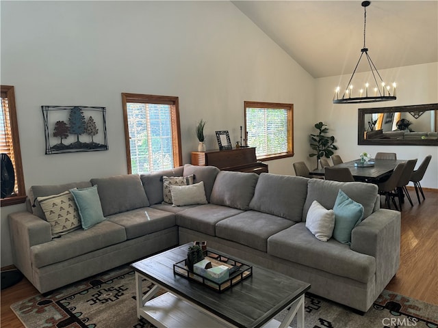 living room with wood-type flooring, high vaulted ceiling, and a healthy amount of sunlight