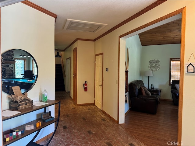 corridor with ornamental molding, vaulted ceiling, and dark hardwood / wood-style flooring