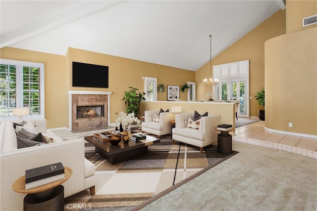 carpeted living room featuring a tiled fireplace, plenty of natural light, a chandelier, and high vaulted ceiling