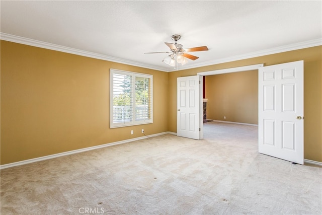 unfurnished bedroom featuring ornamental molding, light colored carpet, and ceiling fan