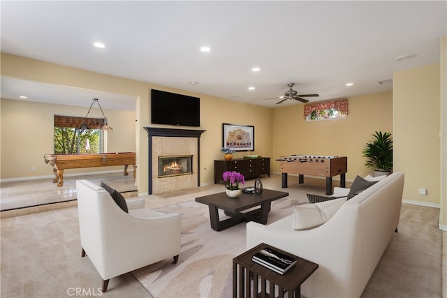 living room with a fireplace, light carpet, pool table, and ceiling fan