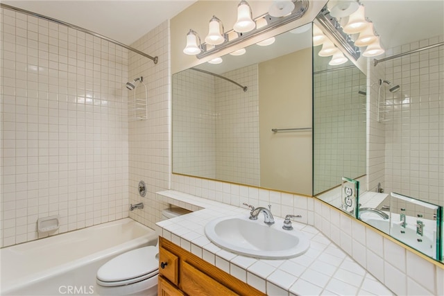 full bathroom with tiled shower / bath, vanity, and toilet