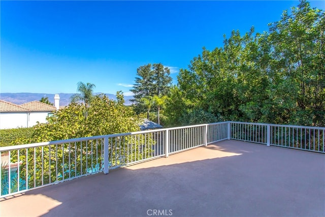 view of patio featuring a mountain view and a balcony