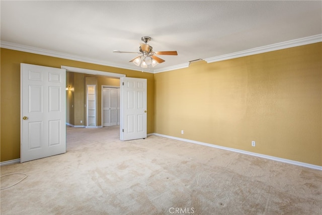 carpeted spare room featuring ceiling fan and ornamental molding