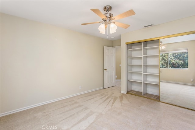 unfurnished bedroom with ceiling fan, a closet, and light carpet