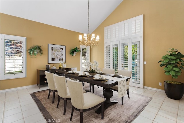 tiled dining room featuring an inviting chandelier and high vaulted ceiling