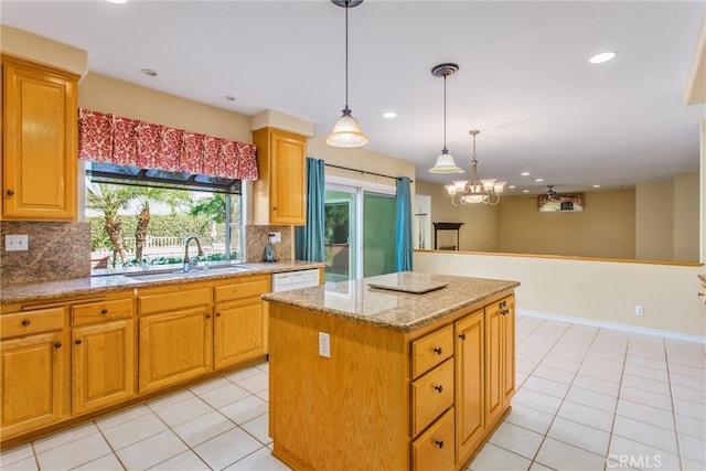 kitchen featuring decorative light fixtures, backsplash, sink, and a center island