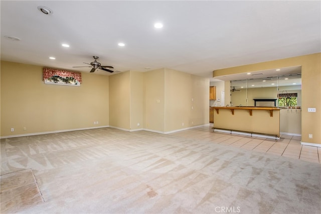 unfurnished living room with light colored carpet and ceiling fan