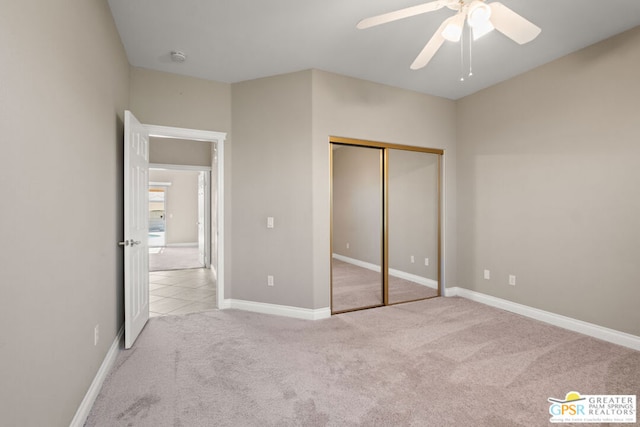 unfurnished bedroom featuring light carpet, ceiling fan, and a closet